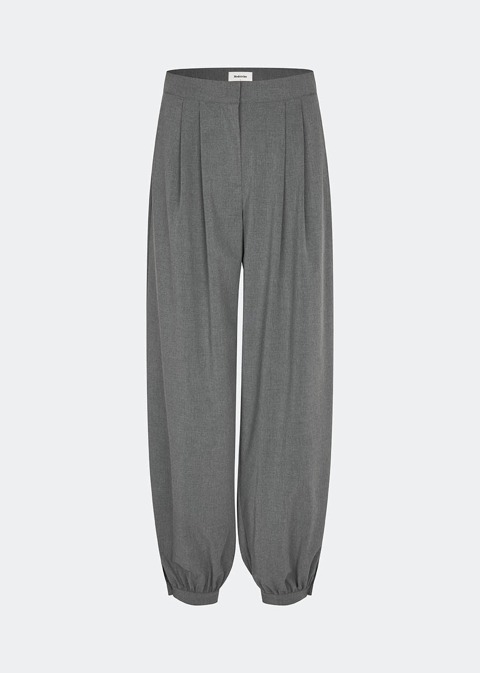 Elegant and modern balloon trousers in grey. TiamoMD pants are designed with soft pleats, volume in the legs, and a subtle button closure at the ankle, creating a modern and refined look. Perfect for both everyday wear and styling with a more sophisticated twist.