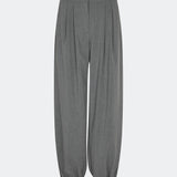 Elegant and modern balloon trousers in grey. TiamoMD pants are designed with soft pleats, volume in the legs, and a subtle button closure at the ankle, creating a modern and refined look. Perfect for both everyday wear and styling with a more sophisticated twist.