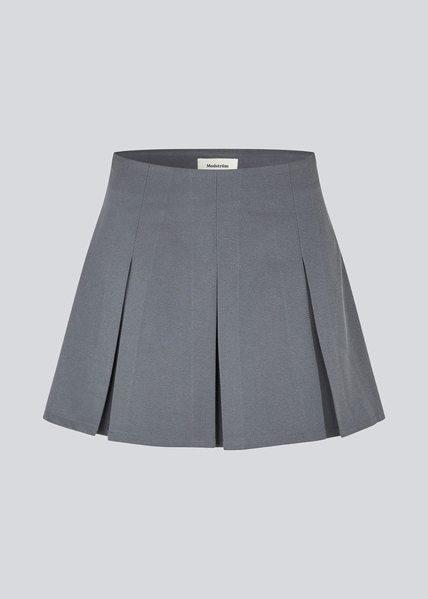 Short skirt in grey with box pleats in a structured material. TianaMD skirt has a hidden zipper on the side.