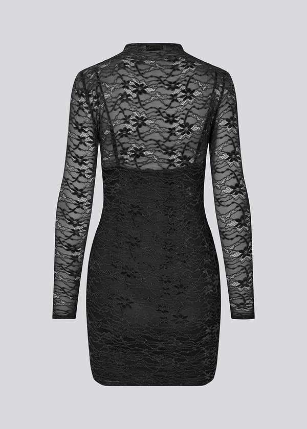 Fitted black lace dress in a see-through lace material. TildeMD dress has long sleeves, a high neck and lining.