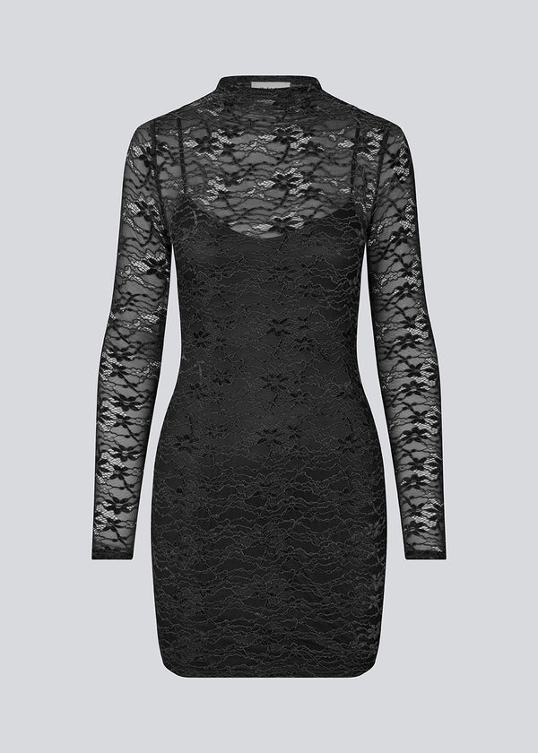 Fitted black lace dress in a see-through lace material. TildeMD dress has long sleeves, a high neck and lining.