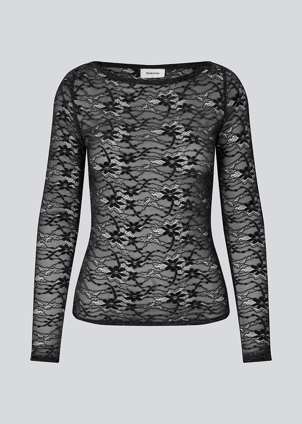 Fitted black top in a see-through lace material. TildeMD top has long sleeves and a wider neckline.