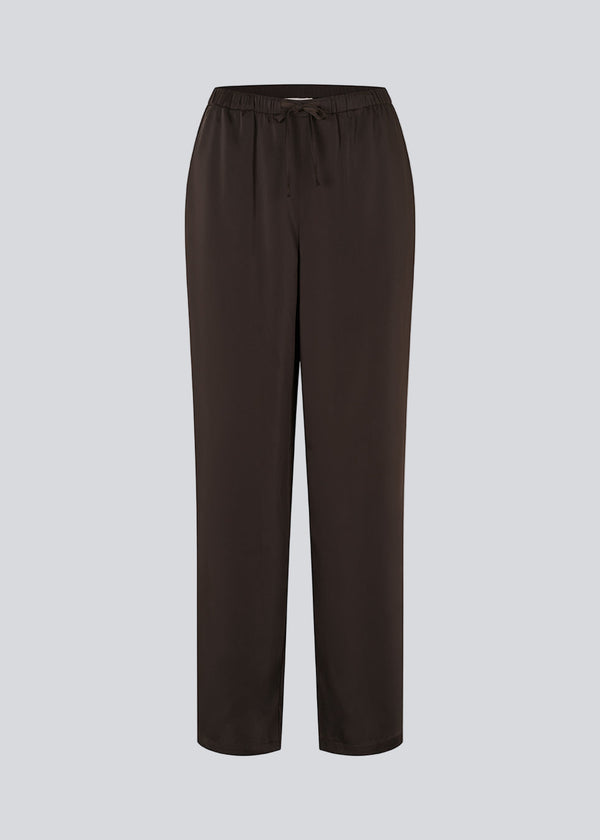 Brown loose satin pants. Timmiemd pants has wide legs, sidepockets, and a tiefastening. A relaxed fit with an elegant look.