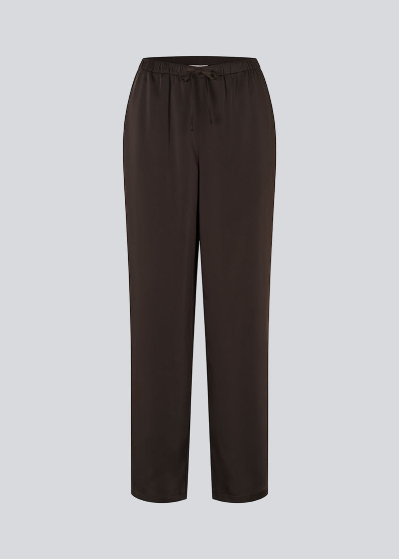 Brown loose satin pants. Timmiemd pants has wide legs, sidepockets, and a tiefastening. A relaxed fit with an elegant look.