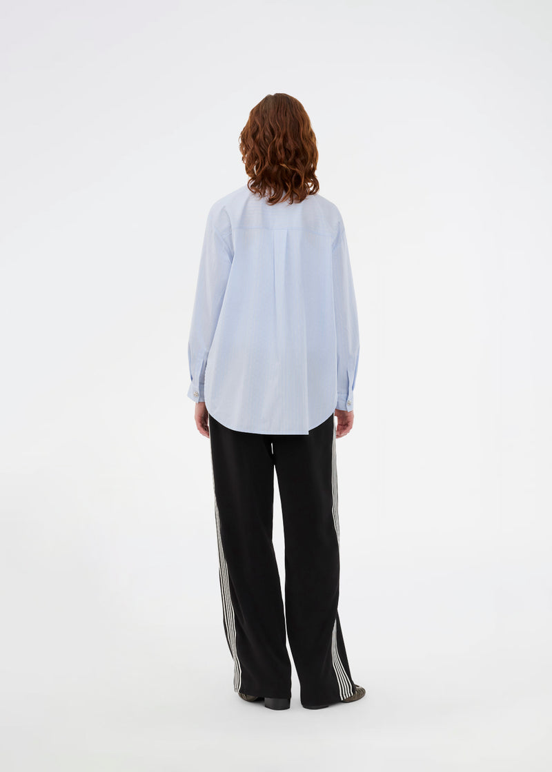 Loose black trousers with wide legs and a relaxed fit. Featuring an elastic waistband with drawstring for a comfortable, adjustable waist. White side stripes add a sporty and modern touch to the otherwise classic design. Perfect for casual everyday wear or more elevated styling – easy to pair with everything from t-shirts to dressy tops.
