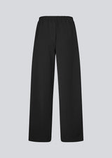 Loose black trousers with wide legs and a relaxed fit. Featuring an elastic waistband with drawstring for a comfortable, adjustable waist. White side stripes add a sporty and modern touch to the otherwise classic design. Perfect for casual everyday wear or more elevated styling – easy to pair with everything from t-shirts to dressy tops.
