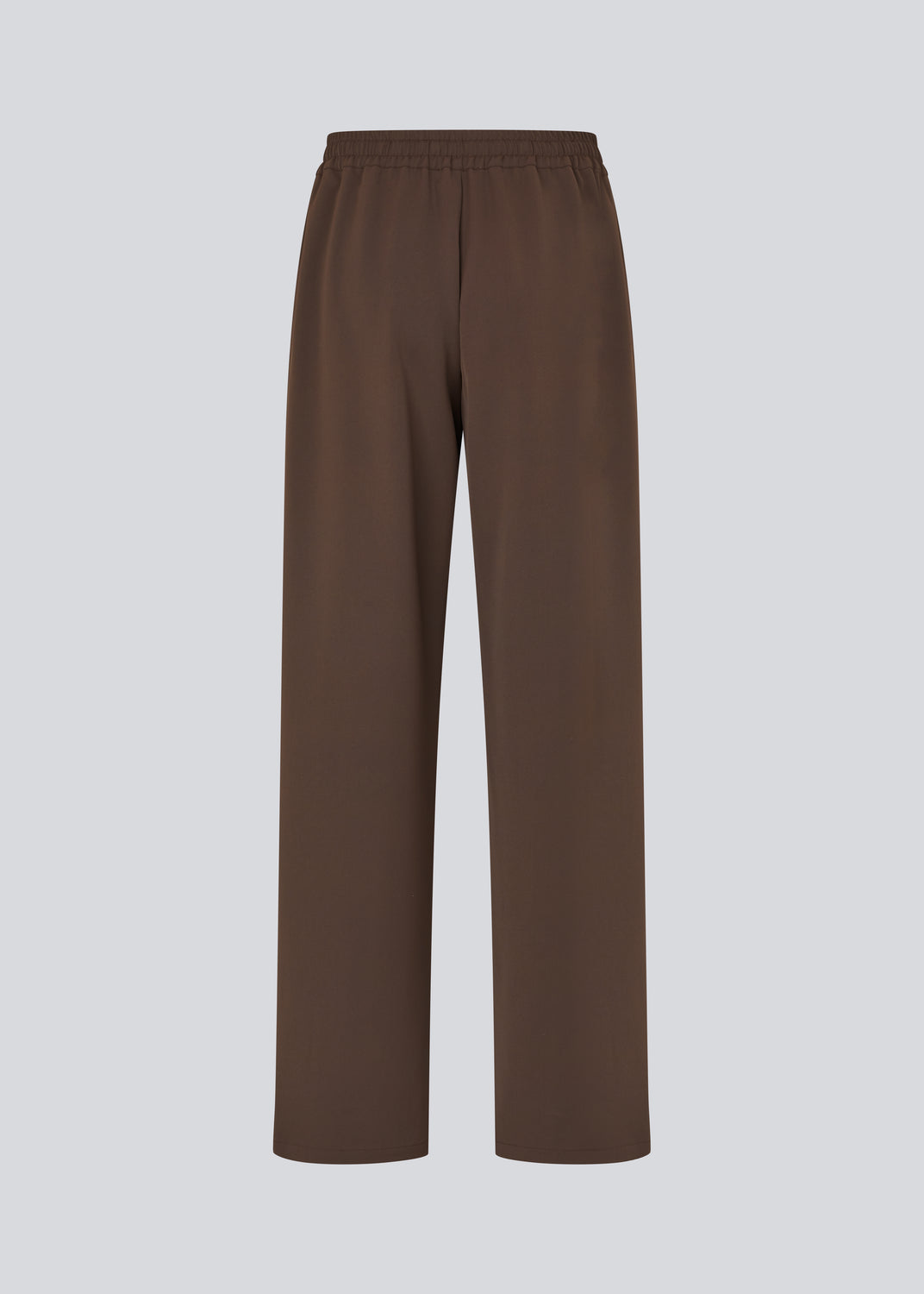 Loose brown trousers with wide legs and a relaxed fit. Featuring an elastic waistband with drawstring for a comfortable, adjustable waist. White side stripes add a sporty and modern touch to the otherwise classic design. Perfect for casual everyday wear or more elevated styling – easy to pair with everything from t-shirts to dressy tops.