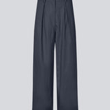 Suit pants in Twill with wide legs and pleats at the top in dark blue. ToreMD pants have a medium-high waist, zipper, side pockets and paspoil pocket in the back.