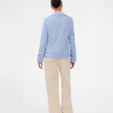 Knitted polo in blue with long sleeves. Treemd polo has a placket closure and 4 buttons. The model is 175 cm and wears a size S/36.