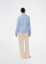 Knitted polo in blue with long sleeves. Treemd polo has a placket closure and 4 buttons. The model is 175 cm and wears a size S/36.