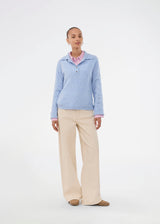 Knitted polo in blue with long sleeves. Treemd polo has a placket closure and 4 buttons. The model is 175 cm and wears a size S/36.