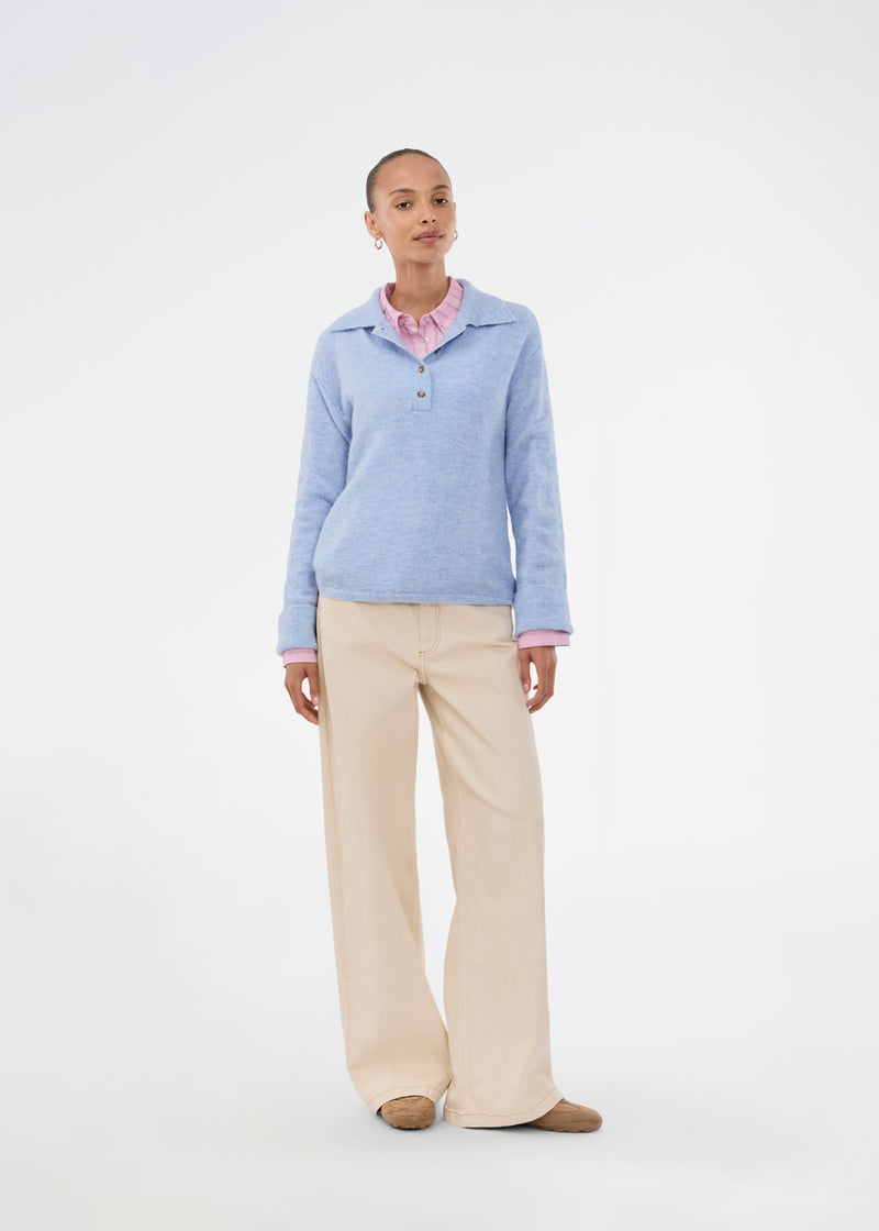 Knitted polo in blue with long sleeves. Treemd polo has a placket closure and 4 buttons. The model is 175 cm and wears a size S/36.