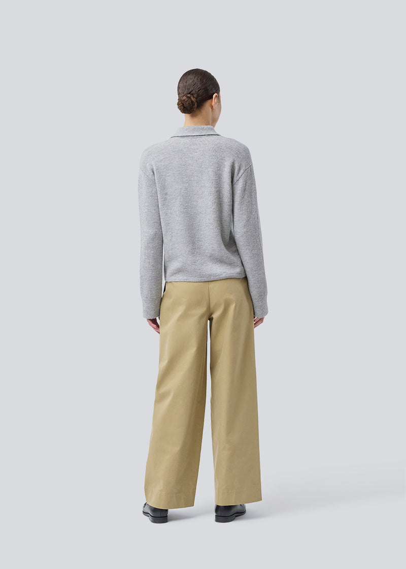 Knitted polo in grey with long, wide sleeves. Treemd polo has a placket closure and 4 buttons. The model is 175 cm and wears a size S/36.