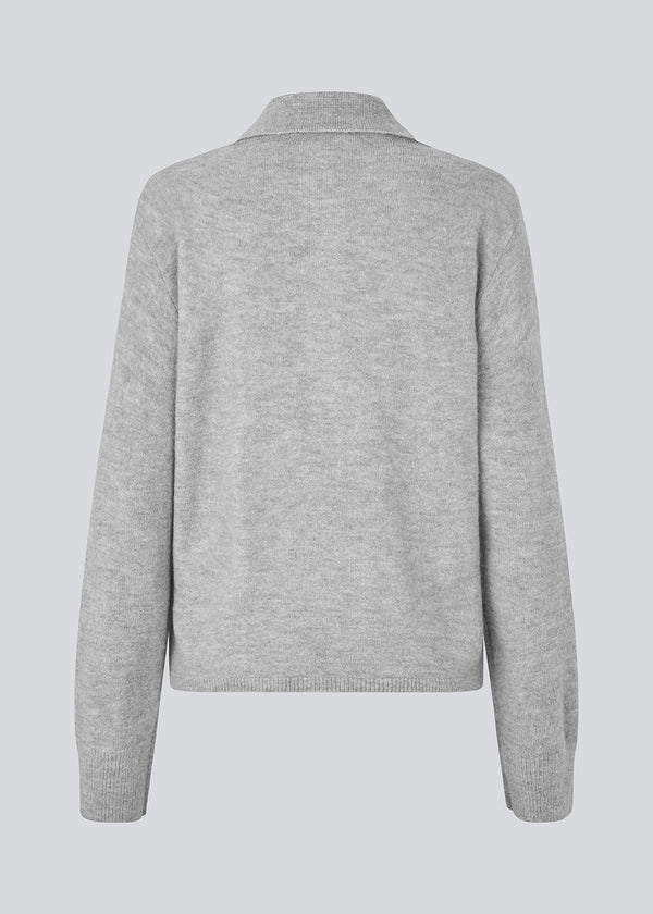 Knitted polo in grey with long, wide sleeves. Treemd polo has a placket closure and 4 buttons. The model is 175 cm and wears a size S/36.