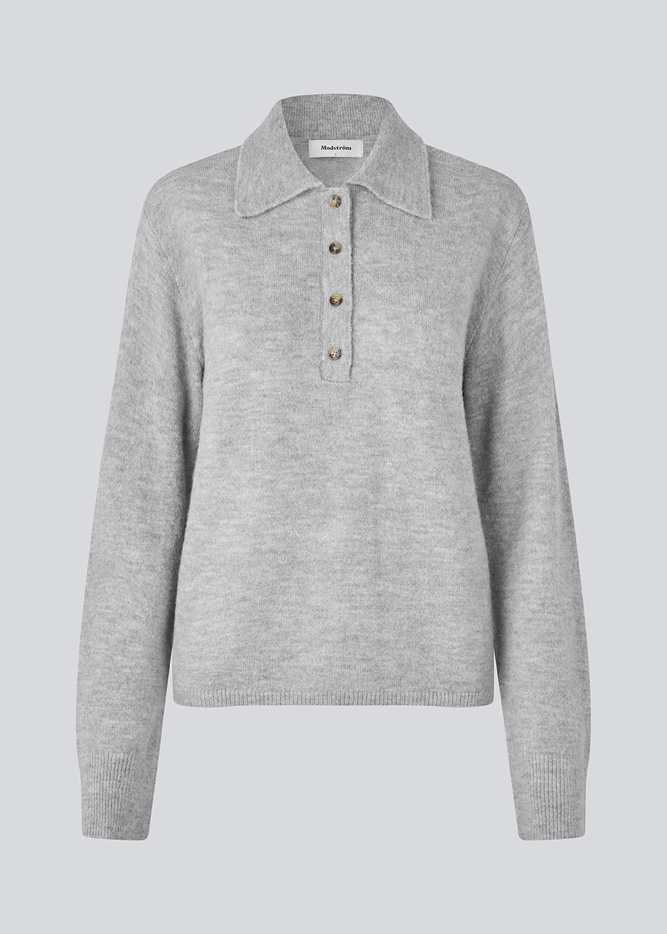 Knitted polo in grey with long, wide sleeves. Treemd polo has a placket closure and 4 buttons. The model is 175 cm and wears a size S/36.