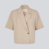 Short-sleeved blazer with a single-button closure. The TuesdayMD SS Blazer features a crossover button closure, collar, side pockets, and a faux chest pocket – a modern twist on a timeless classic. Can be worn closed as an elegant top or open over a light blouse for a more relaxed look.