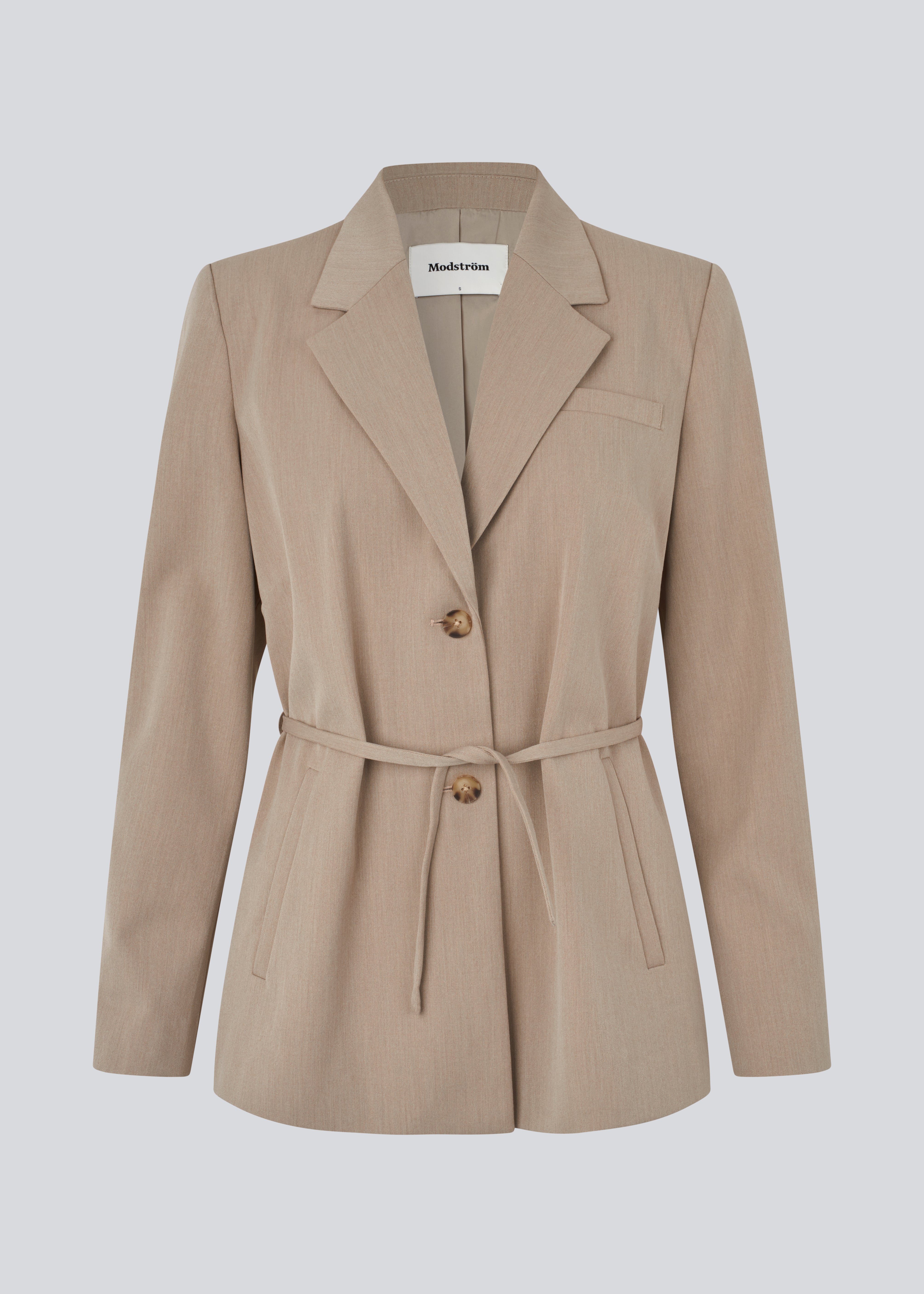 Classic blazer in beige with a tie belt at the waist. The UcheMD blazer features a straight cut, long sleeves, button closure, as well as side pockets and a chest pocket – made from 63% recycled polyester. The model is 175 cm and wears a size S/36.

Style the blazer with matching pants
Material:
4% Elastane
63% Recycled Polyester
33% Rayon

Lining:
100% Polyester