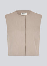 Minimalist vest in beige with clean lines. The UcheMD vest is sleeveless with a round neckline and a concealed closure – perfect for layering or worn on its own. Made from 63% recycled polyester.

Style the vestwith matching pants: Uchemd pants

Material:
4% Elastane
63% Recycled Polyester
33% Rayon

Lining:
100% Polyester