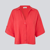 Minimalist shirt in red with wide 3/4 sleeves. The UddinMD Shirt features a loose and comfortable fit, a classic shirt collar, a feminine V-neckline, and button closure. The model is 175 cm and wears a size S/36.

Material:
27% Polyamide
73% Viscose