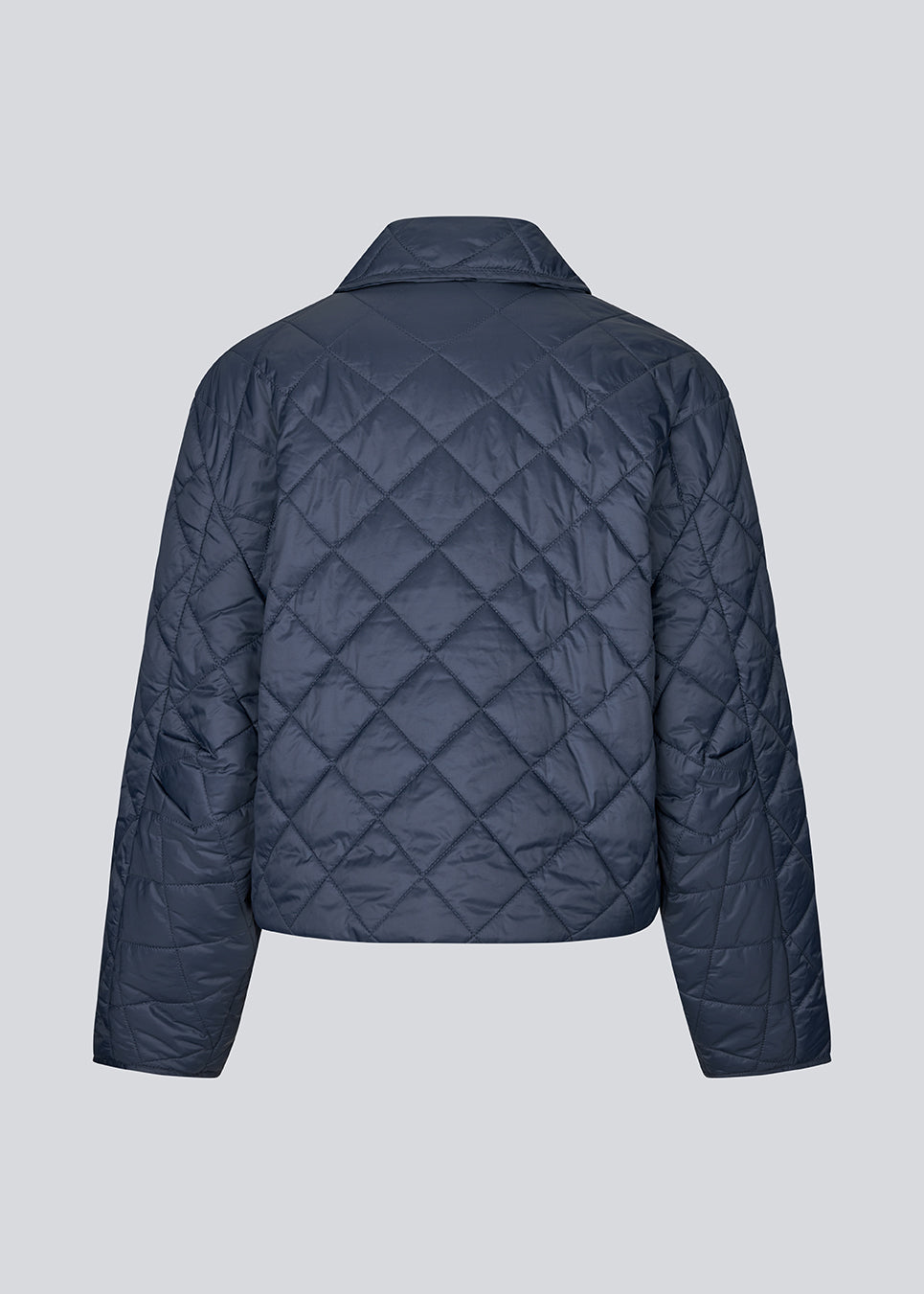 Short navy quilted jacket in 100% recycled nylon. The Uffemd jacket has a light, casual look with a shirt collar, press buttons, and practical side pockets – an ideal layer for the transitional seasons. The model is 175 cm and wears a size S/36.


Material:
100% Recycled nylon

Lining:
100% Polyester

Filling:
100% Polyester
