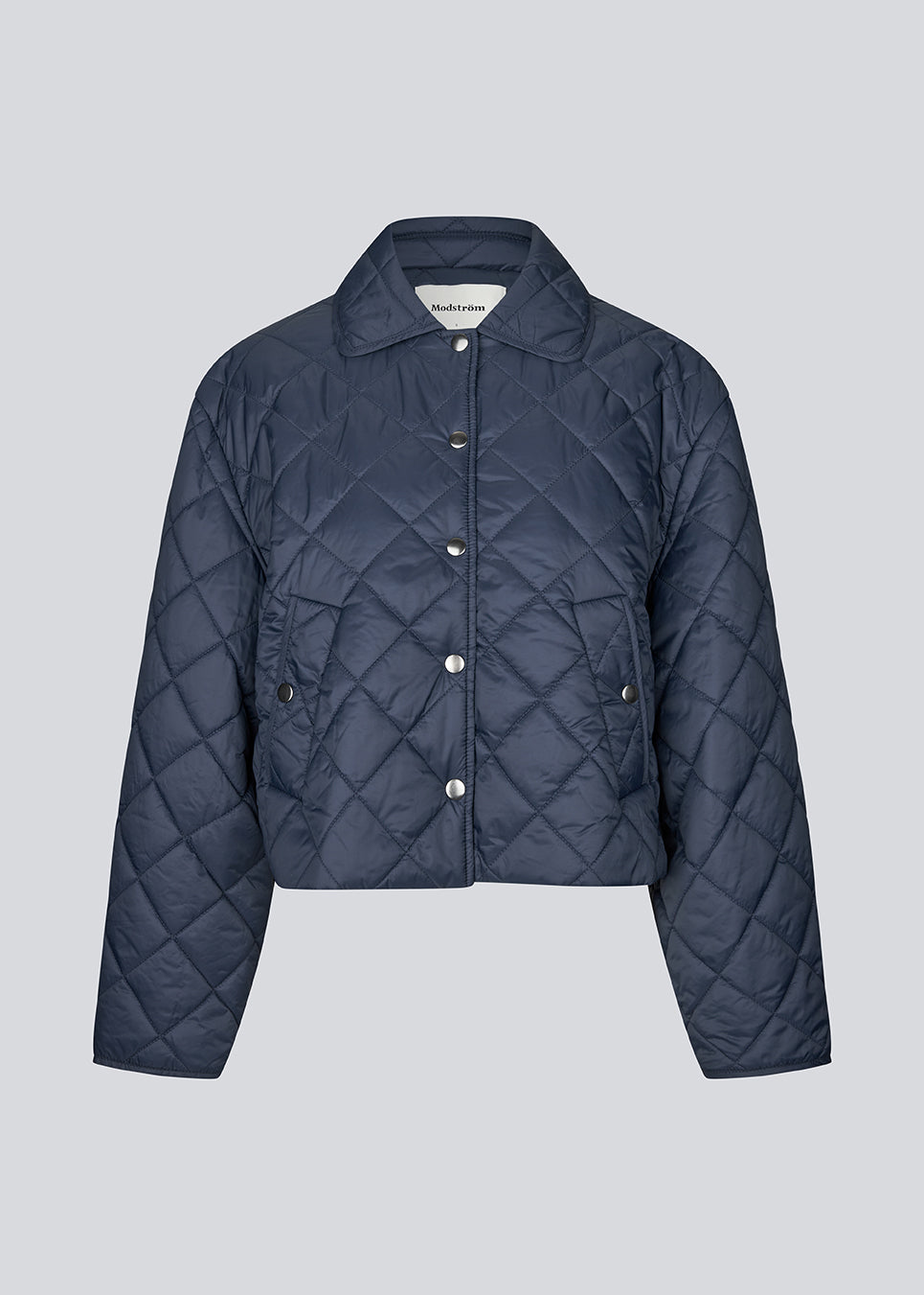 Short navy quilted jacket in 100% recycled nylon. The Uffemd jacket has a light, casual look with a shirt collar, press buttons, and practical side pockets – an ideal layer for the transitional seasons. The model is 175 cm and wears a size S/36.


Material:
100% Recycled nylon

Lining:
100% Polyester

Filling:
100% Polyester