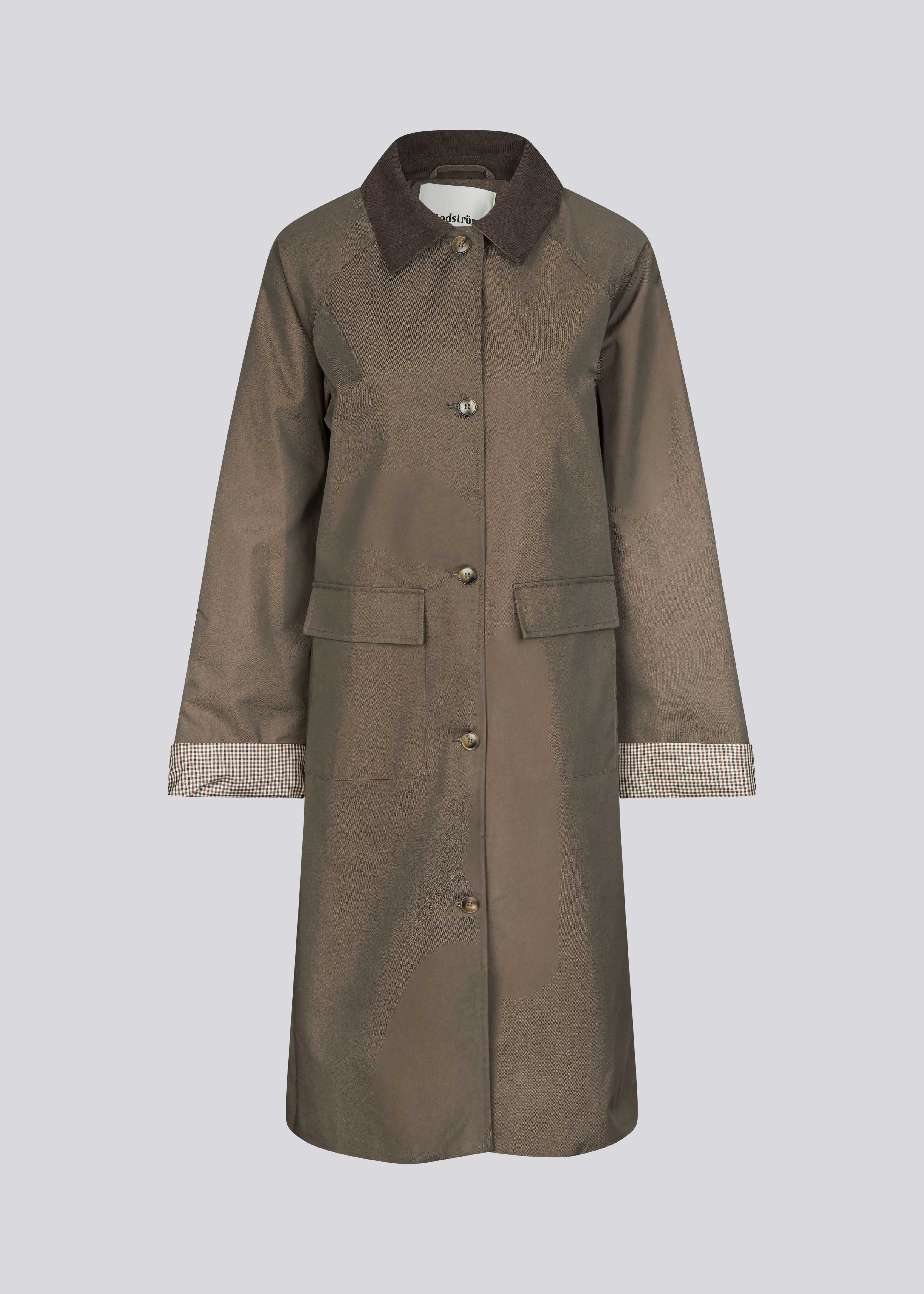 Modern coat with a shirt collar in corduroy and checked sleeve turn-ups. The Ullamd coat is long with wide sleeves, button closure, and spacious pockets.
