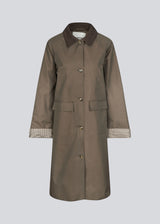 Modern coat with a shirt collar in corduroy and checked sleeve turn-ups. The Ullamd coat is long with wide sleeves, button closure, and spacious pockets.