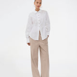 A modern interpretation of the classic shirt in white. The UllisMD Shirt is made from 97% organic cotton and designed with a pointed collar, half button closure, and a feminine, fitted silhouette that creates an elegant and sophisticated look. The model is 175 cm and wears a size S/36.

Material:
97% Organic Cotton
3% Elastane