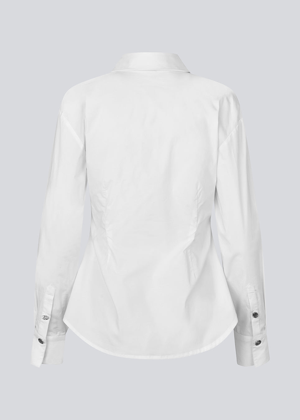 A modern interpretation of the classic shirt in white. The UllisMD Shirt is made from 97% organic cotton and designed with a pointed collar, half button closure, and a feminine, fitted silhouette that creates an elegant and sophisticated look. The model is 175 cm and wears a size S/36.

Material:
97% Organic Cotton
3% Elastane