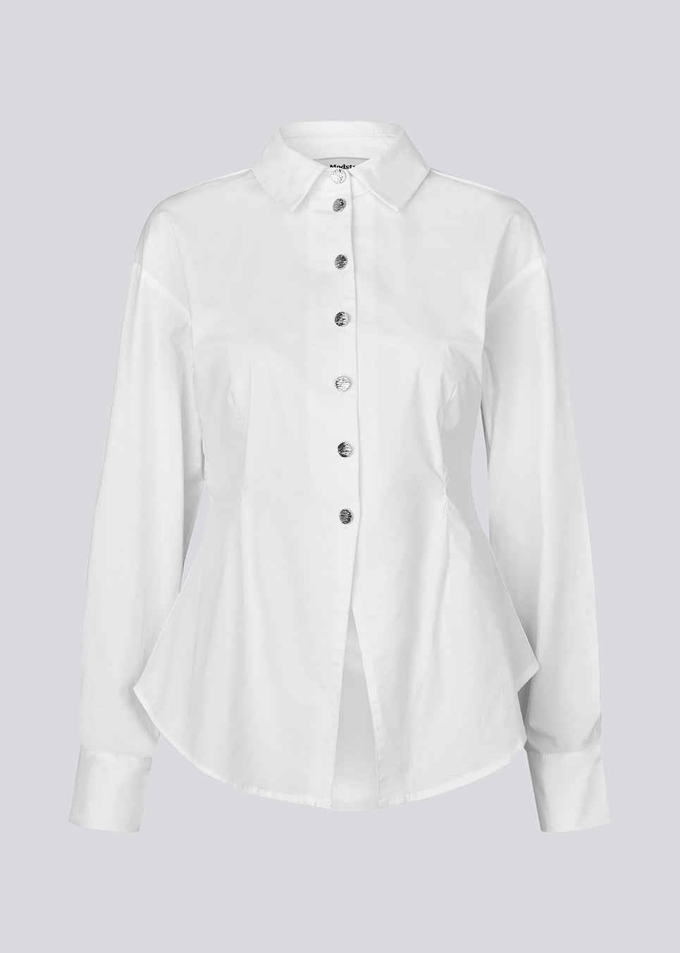 A modern interpretation of the classic shirt in white. The UllisMD Shirt is made from 97% organic cotton and designed with a pointed collar, half button closure, and a feminine, fitted silhouette that creates an elegant and sophisticated look. The model is 175 cm and wears a size S/36.

Material:
97% Organic Cotton
3% Elastane
