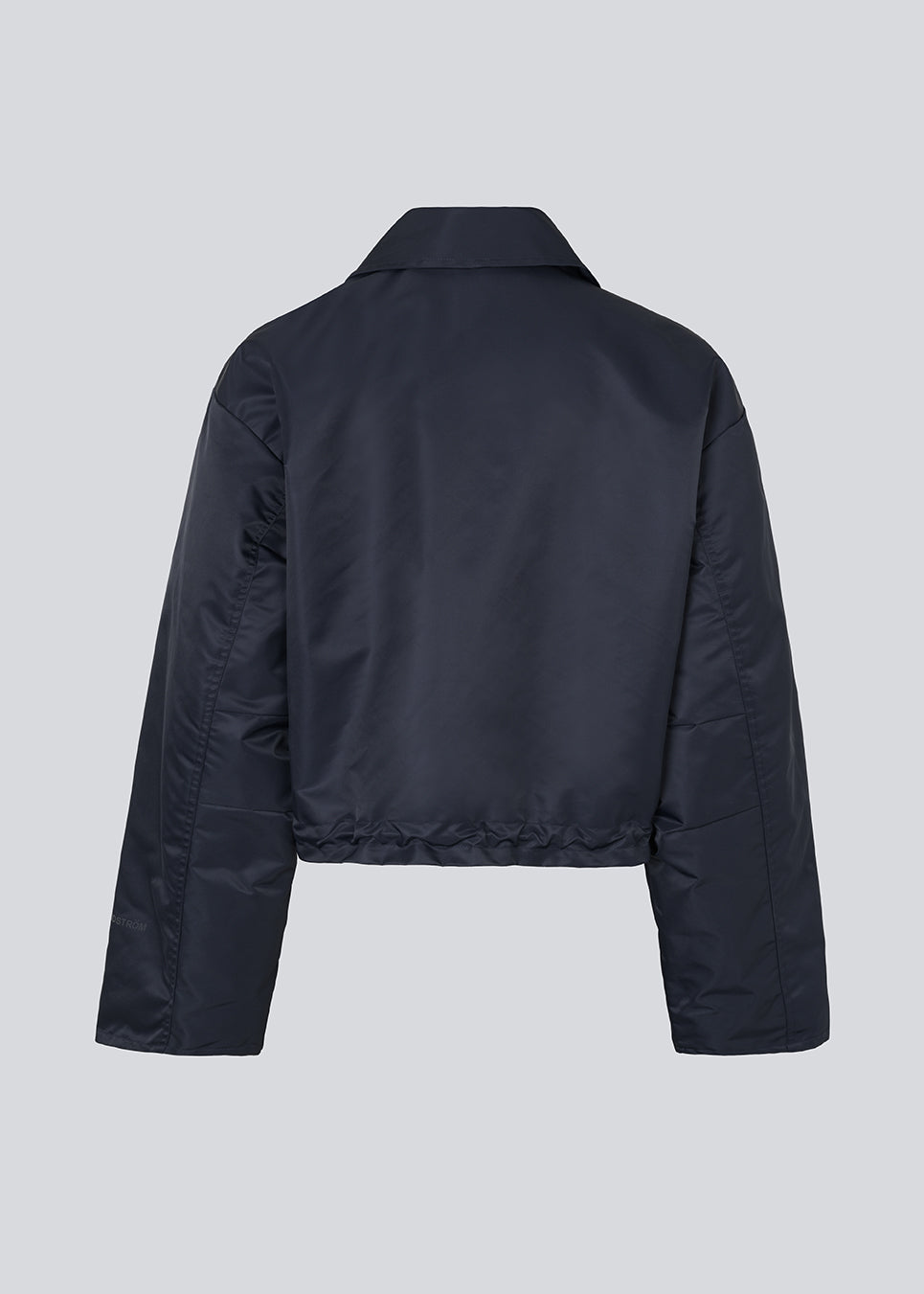 Short jacket in navy with modern and practical details. The Ulrikkemd jacket features a classic collar, large front flap pockets, an adjustable drawstring at the waist, and is crafted from glossy nylon that gives it a sleek and sporty look. The model is 175 cm and wears a size S/36.

Material:
100% Nylon

Lining:
100% Polyester

Filling:
100% Polyester
