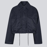 Short jacket in navy with modern and practical details. The Ulrikkemd jacket features a classic collar, large front flap pockets, an adjustable drawstring at the waist, and is crafted from glossy nylon that gives it a sleek and sporty look. The model is 175 cm and wears a size S/36.

Material:
100% Nylon

Lining:
100% Polyester

Filling:
100% Polyester