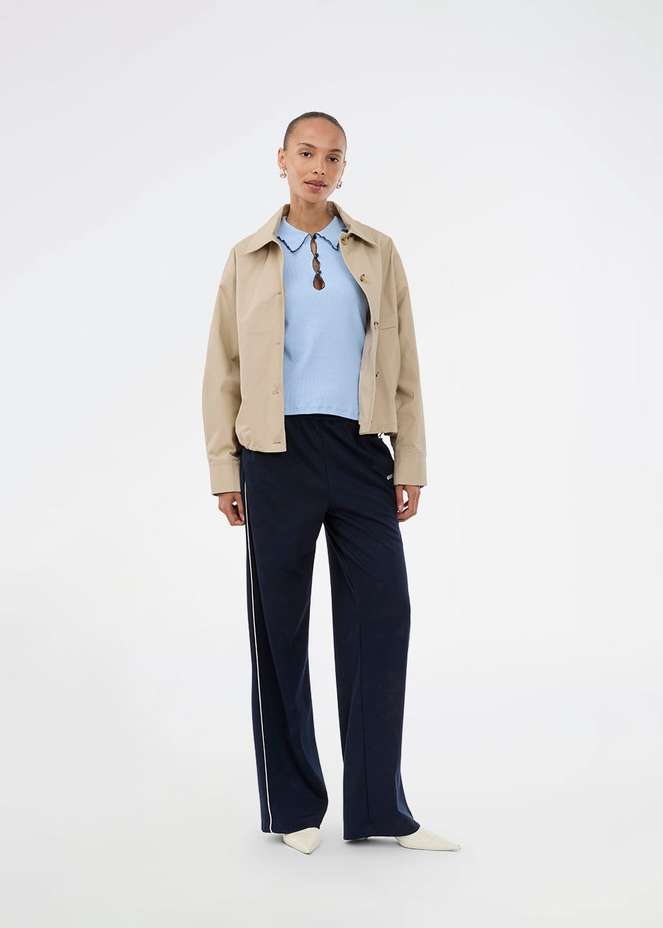 Short jacket i beige with a trench coat look. The Umamd jacket features a shirt collar, side pockets, button closure, and an adjustable elastic hem. The model is 175 cm and wears a size S/36.

Material:
97% Cotton
3% Elastane

Lining:
100% Polyester