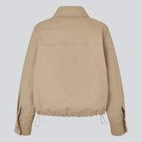 Short jacket i beige with a trench coat look. The Umamd jacket features a shirt collar, side pockets, button closure, and an adjustable elastic hem. The model is 175 cm and wears a size S/36.

Material:
97% Cotton
3% Elastane

Lining:
100% Polyester