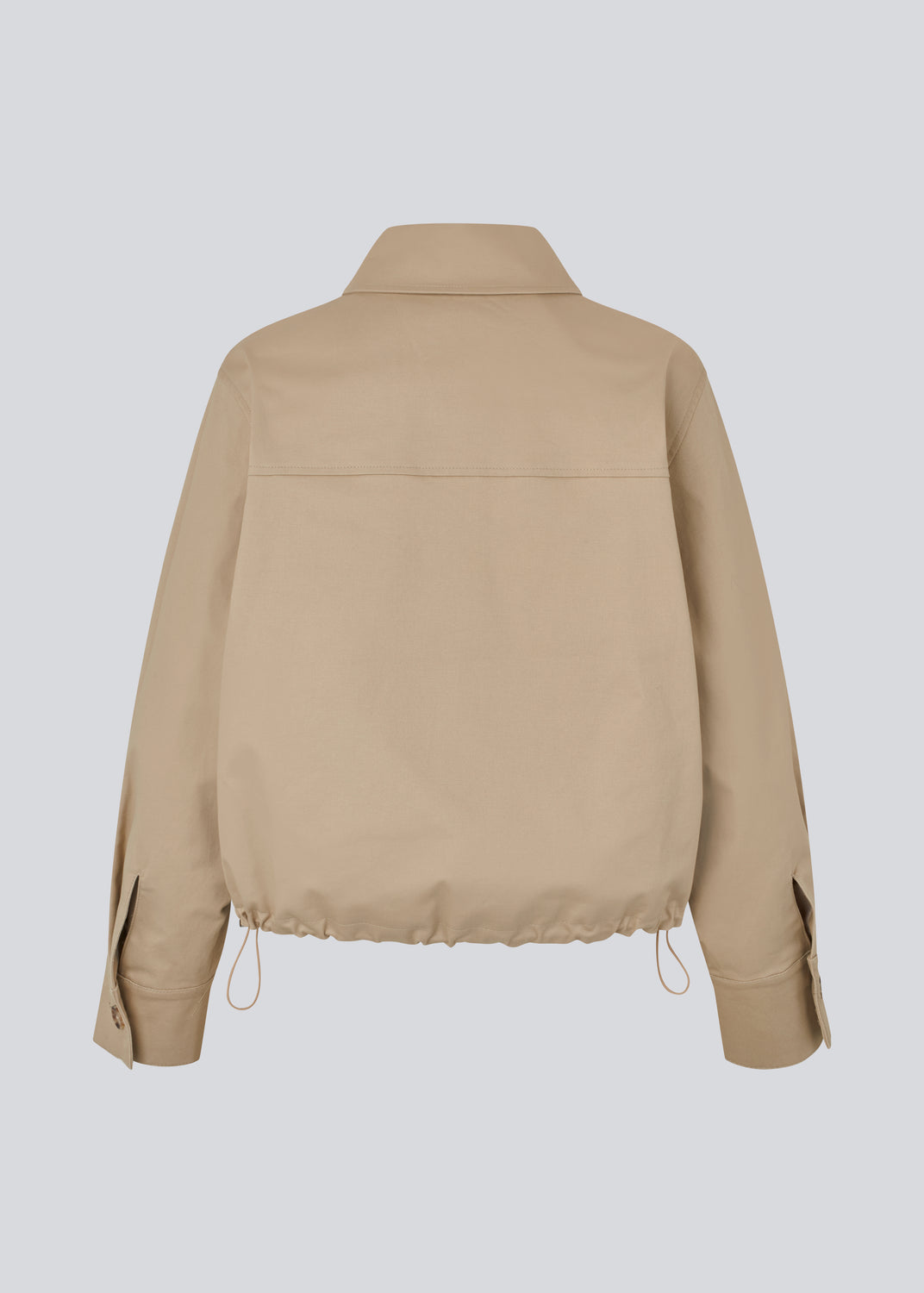 Short jacket i beige with a trench coat look. The Umamd jacket features a shirt collar, side pockets, button closure, and an adjustable elastic hem. The model is 175 cm and wears a size S/36.

Material:
97% Cotton
3% Elastane

Lining:
100% Polyester