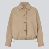 Short jacket i beige with a trench coat look. The Umamd jacket features a shirt collar, side pockets, button closure, and an adjustable elastic hem. The model is 175 cm and wears a size S/36.

Material:
97% Cotton
3% Elastane

Lining:
100% Polyester