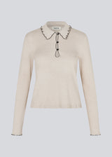 Elegant knitted blouse in beige with contrast stitching. The UrdMD LS Top is made from 100% organic cotton and features a collar, long sleeves, and button detailing. A timeless and feminine choice for any occasion. The model is 175 cm and wears a size S/36. 

Material:
95% Organic Cotton
5% Elastane
