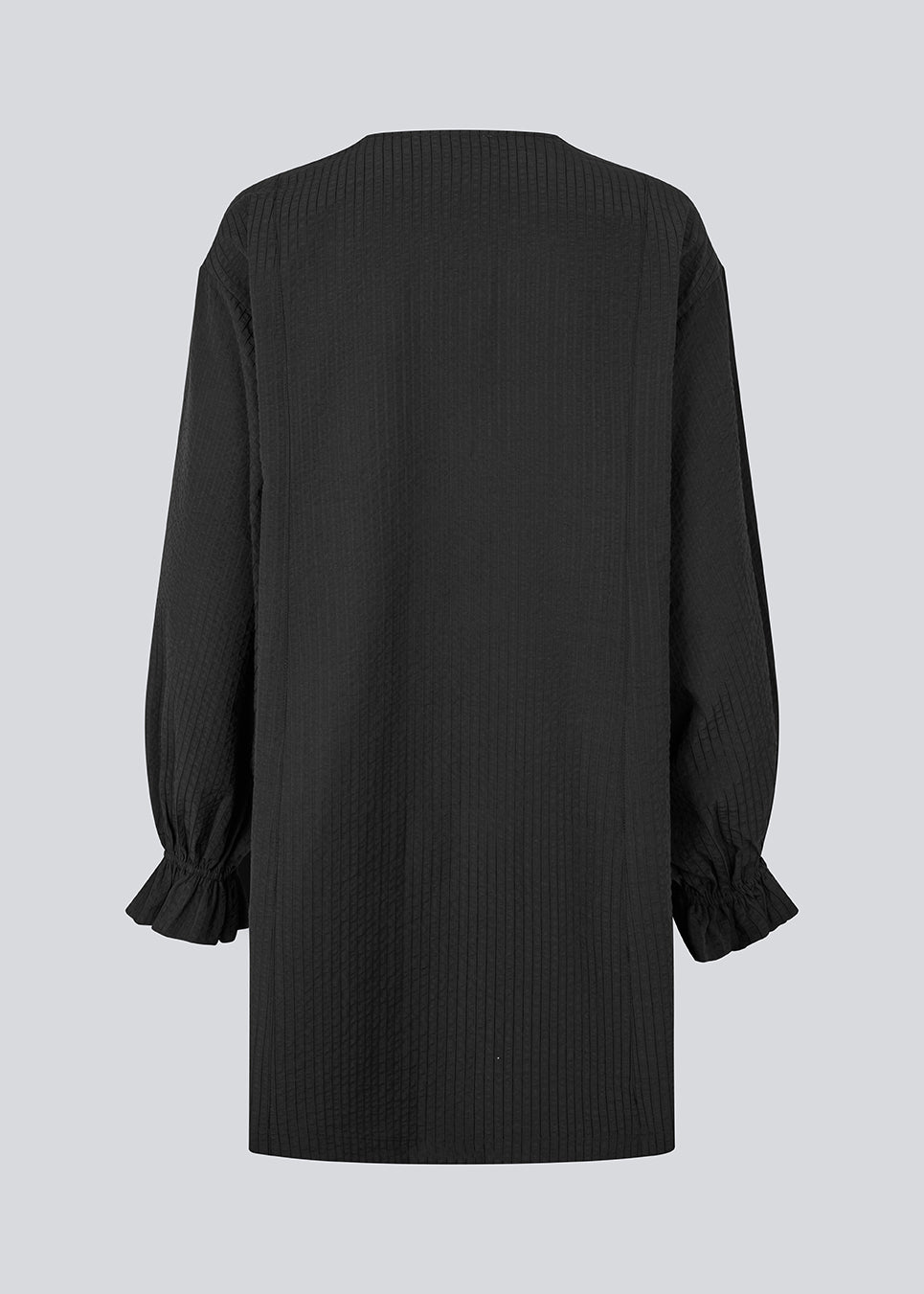 Elegant black dress in a lightweight textured fabric. The UrsaMD Dress features a relaxed, straight fit with long, voluminous sleeves and feminine ruffle details at the wrists. The round neckline has a small V-cut with tie strings, adding a delicate and relaxed touch.

Material:
40% Cotton
60% Recycled Polyester