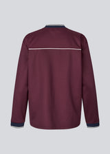 Dark red tracksuit top made from 100% recycled polyester. Utopiamd LS t-shirt has long sleeves, a v-neck with contrast details and a front logo.