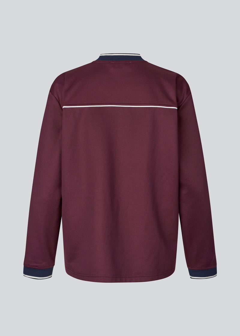 Dark red tracksuit top made from 100% recycled polyester. Utopiamd LS t-shirt has long sleeves, a v-neck with contrast details and a front logo.