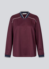 Dark red tracksuit top made from 100% recycled polyester. Utopiamd LS t-shirt has long sleeves, a v-neck with contrast details and a front logo.