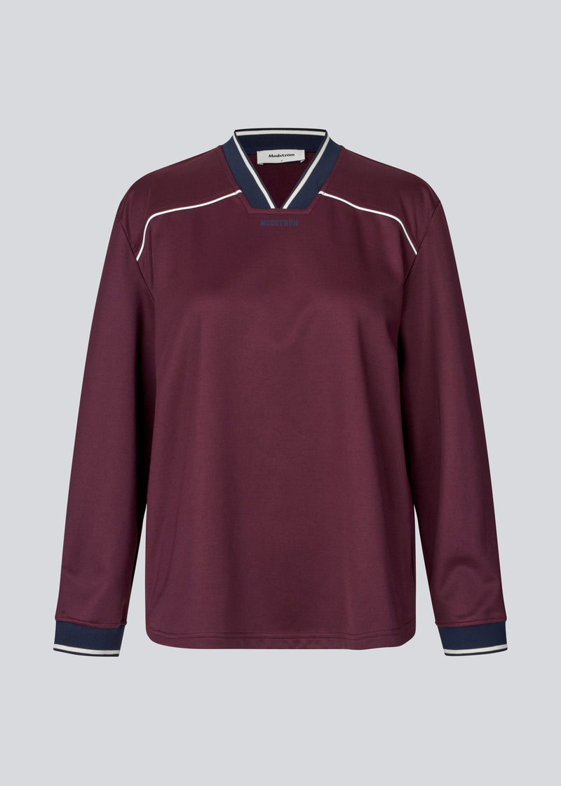 Dark red tracksuit top made from 100% recycled polyester. Utopiamd LS t-shirt has long sleeves, a v-neck with contrast details and a front logo.