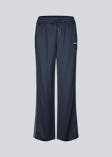 Tracksuitpants in navy blue with wide legs in 100% recycled polyester. Utopiamd pants has sidepockets, logo and an elastic waistband with tiebands. The model is 175 cm and wears a size S/36.

Material:
50% Cotton
50% Polyester