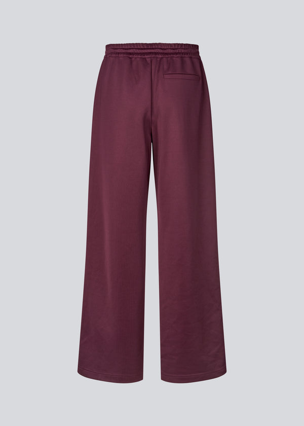 Dark red tracksuitpants with wide legs in 100% recycled polyester. Utopiamd pants has sidepockets, logo and an elastic waistband with tiebands.