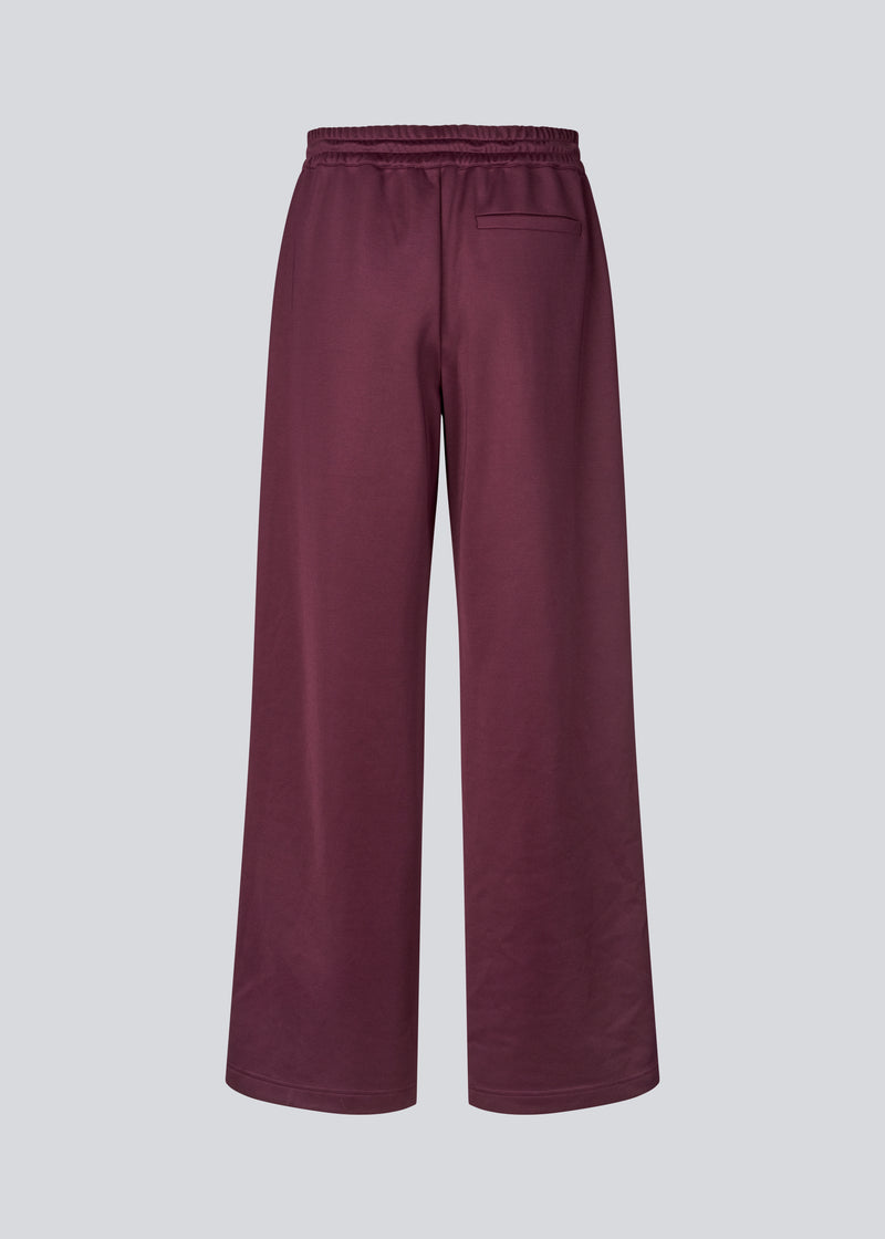 Dark red tracksuitpants with wide legs in 100% recycled polyester. Utopiamd pants has sidepockets, logo and an elastic waistband with tiebands.