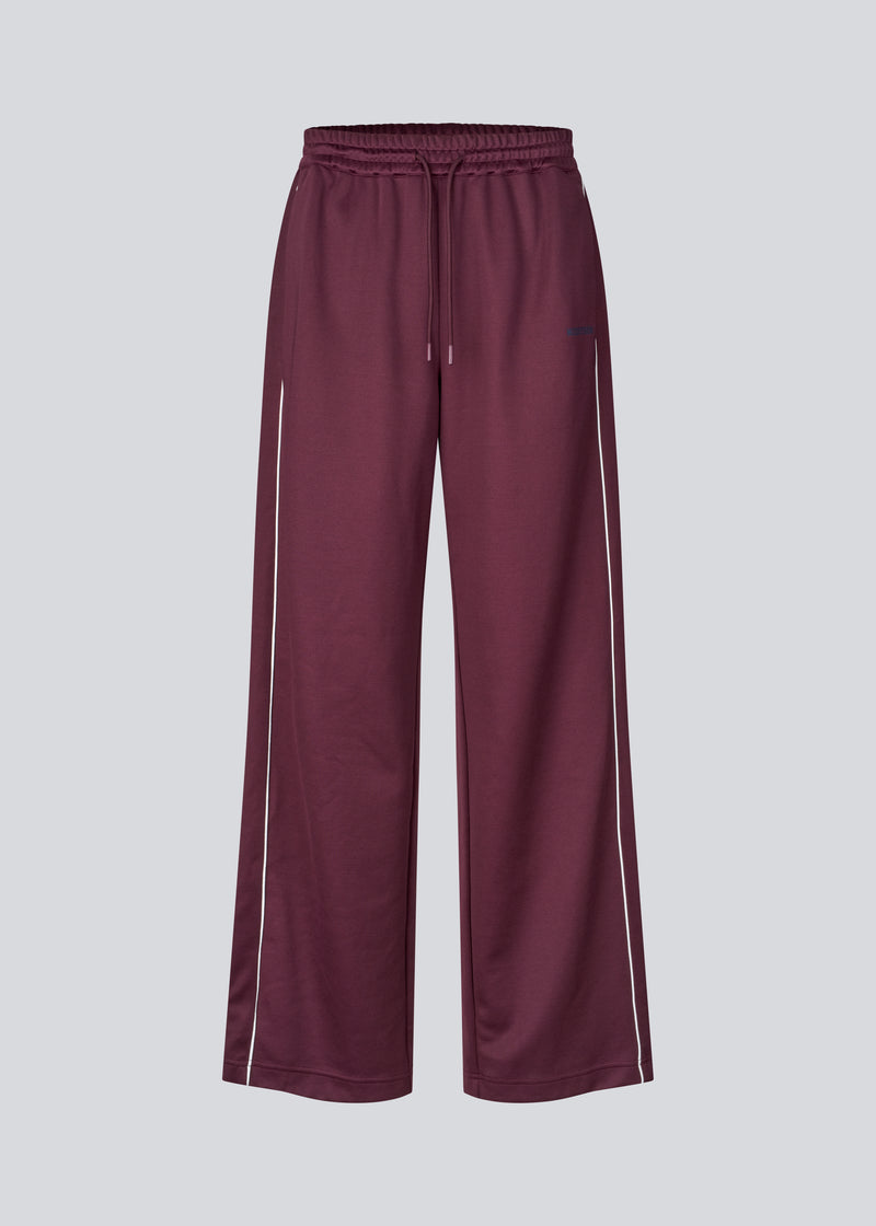 Dark red tracksuitpants with wide legs in 100% recycled polyester. Utopiamd pants has sidepockets, logo and an elastic waistband with tiebands.