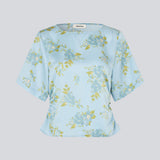 Light and feminine blouse in blue with a romantic floral print. The UttaMD SS Top is designed with short, wide sleeves and a relaxed fit for an elegant and effortless look. Made from 100% recycled polyester. The model is 175 cm and wears a size S/36.

Material:
100% Recycled Polyester