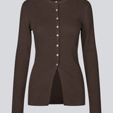 Timeless rib-knit cardigan in brown with a round neckline and front button closure. The UvisMD Cardigan features a fitted silhouette and a soft quality that gives it a feminine and elegant look. Perfect for everyday wear and layering through the seasons. The model is 175 cm and wears a size S/36.

Material:
100% Organic Cotton