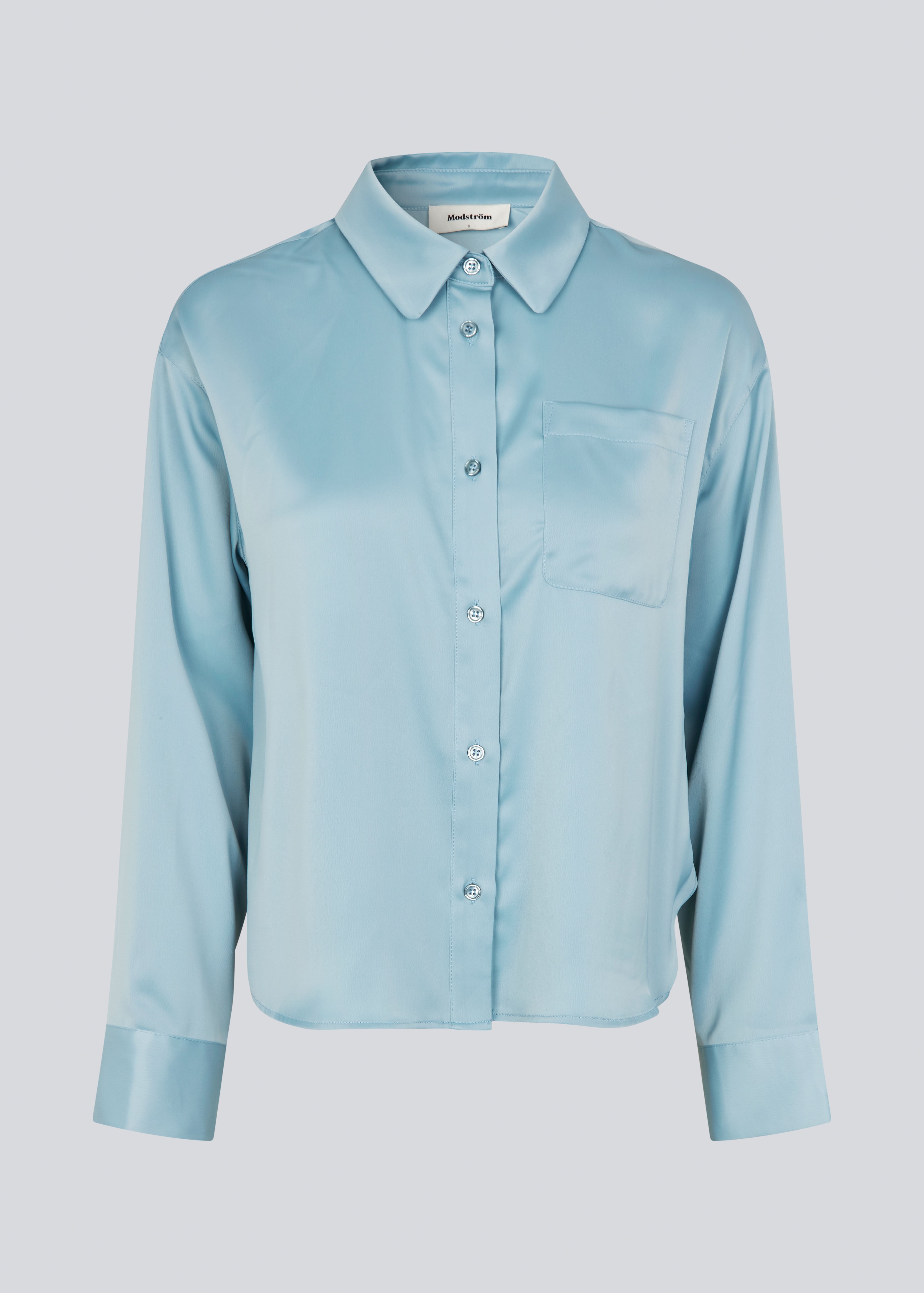 Feminine shirt in blue in lustrous satin. The Valdomd shirt features classic details such as a chest pocket, long sleeves, button closure, and a length that reaches the waistband. Made from 98% recycled polyester, this shirt is perfect for both elegant and casual looks.

Style with matching pants.&nbsp;