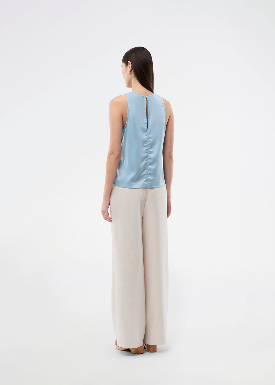Sleeveless top in blue in lustrous satin. The Valdomd Top features a round neckline, vertical stitching detail at the front, and a button closure at the back for an elegant look. Made from 98% recycled polyester&nbsp;